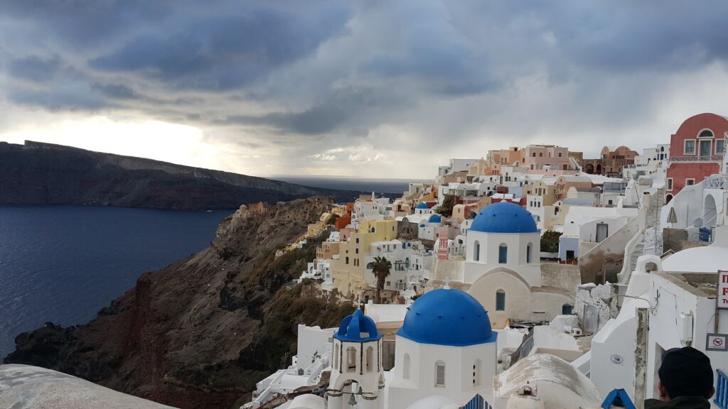 Panoramic view of Oia's whitewashed buildings perched on the caldera cliffs