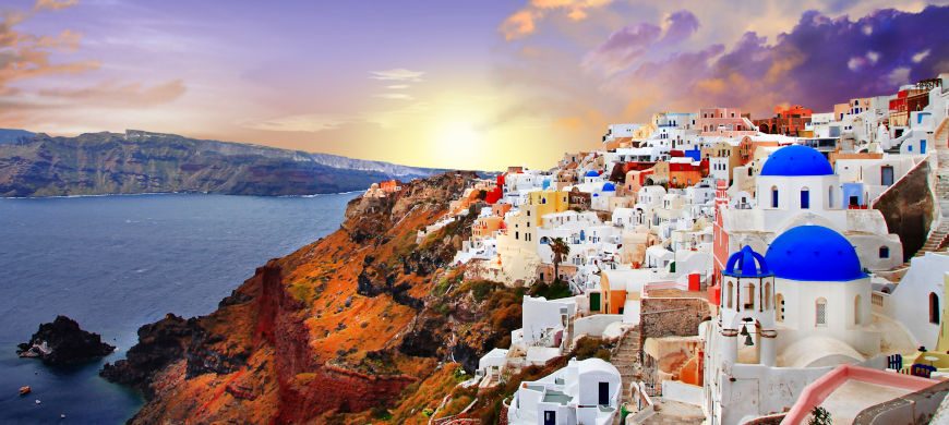 Whitewashed buildings and blue-domed churches perched on the caldera cliffs of Oia, Santorini