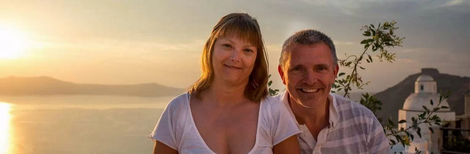 A couple posing with Santorini sunset on the background