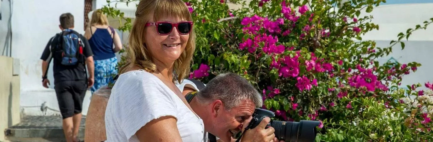 A smiling woman looking straight to the camera and a man talking other photographs of Santorini