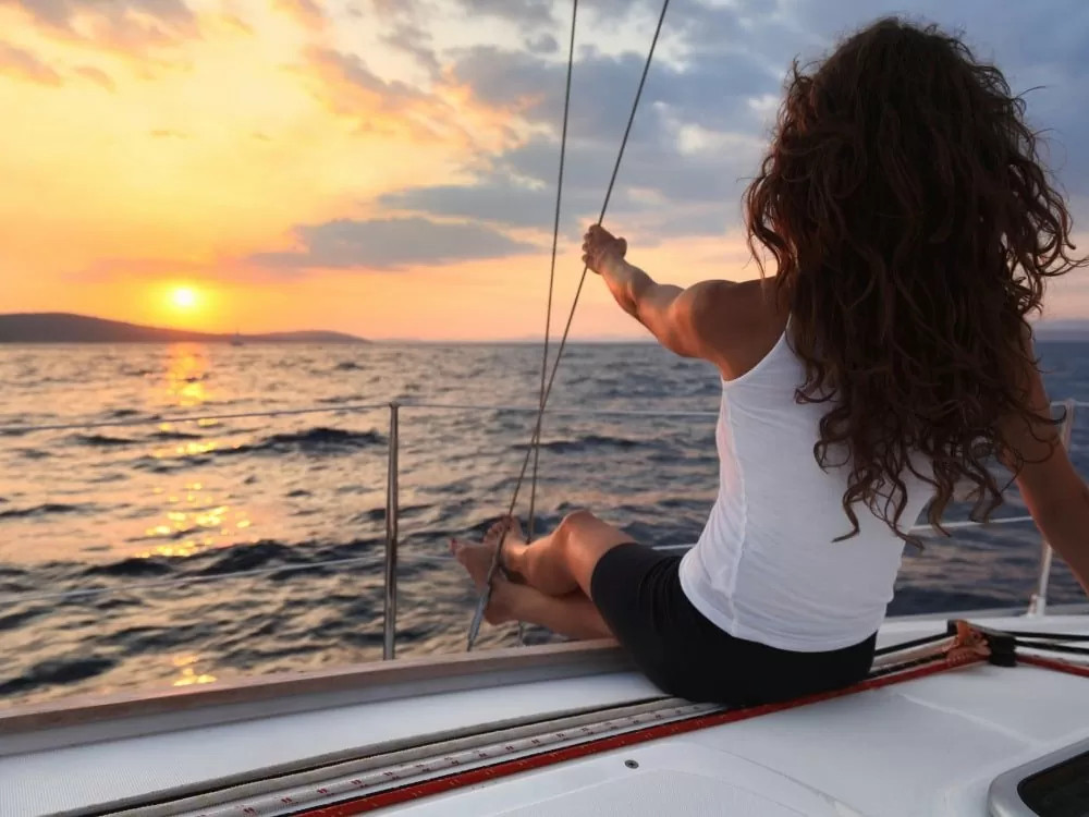 A woman enjoying the sunset on a Sunset Sailing in Santorini