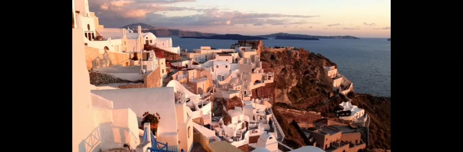 White-washed houses perched on Santorini caldera during the golden hour