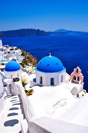 Panoramic view of a Santorini blue domed church and the Aegean Sea